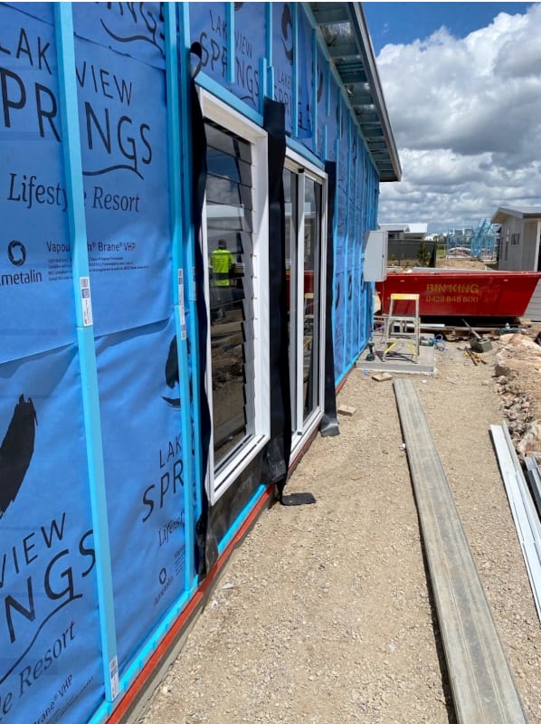 a building under construction with blue wall wrap and ATI Cavi-Vent cavity batten strips